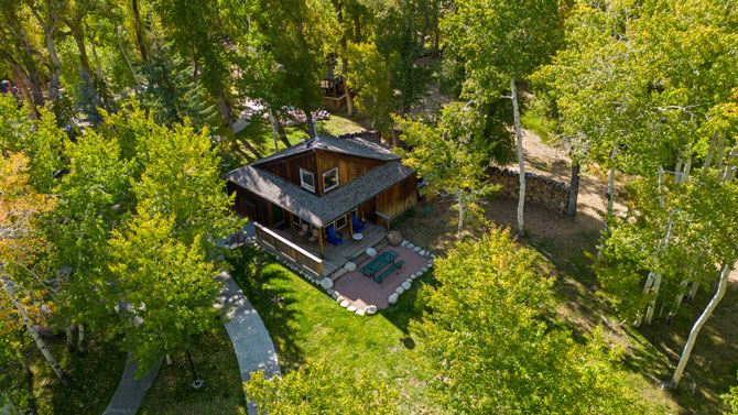 Overhead view of shaded cabin with porch and bbq at Creekside Chalets and Cabins in Salida, Colorado.