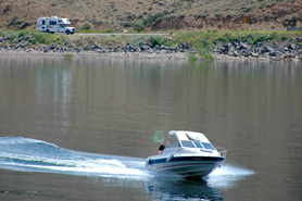 Boat on Blue Mesa Reservoir with RV in the background near West Elk Loop Scenic Byway in Colorado